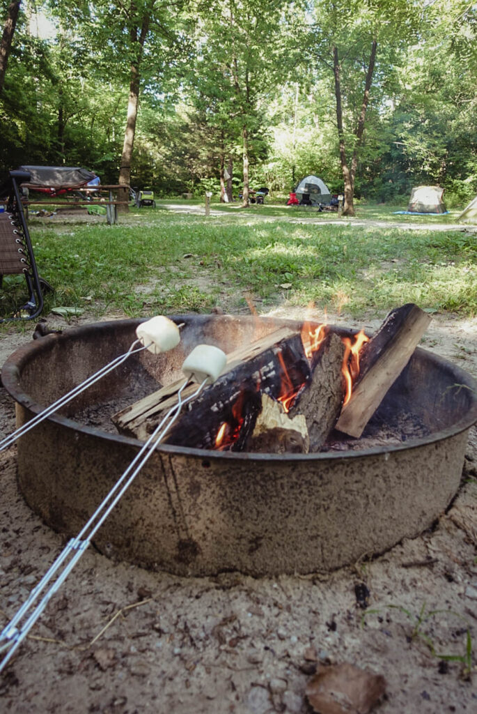 roasting s'mores over a camp fire first time camping - tent camping for beginners