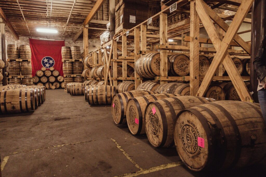 The Nashville flag hung over whiskey barrels at the Nelson Green Briar Distillery in Nashville - Nashville Weekend Itinerary