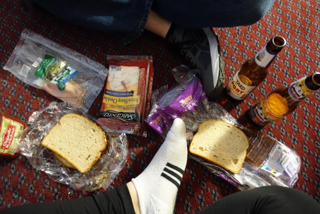 making sandwiches on the floor of a hotel room to save money while traveling
