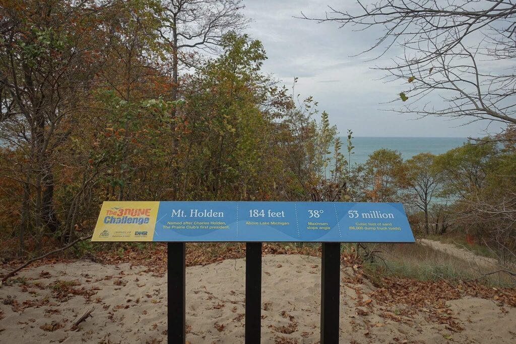 A Sign at the top of Mount Holden that says 184 Feet, 38 degree elevation, 3 dune challenge.